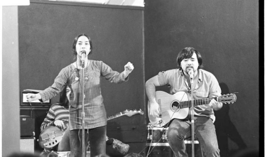 performance by nobuko miyamoto singing and man playing guitar